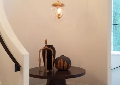 A spiral staircase with a bench and a light fixture.