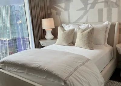 A bedroom with a large bed and a large window.