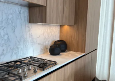 A kitchen with wooden cabinets and marble counter tops.