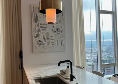 A kitchen with marble counter tops and a view of the city.